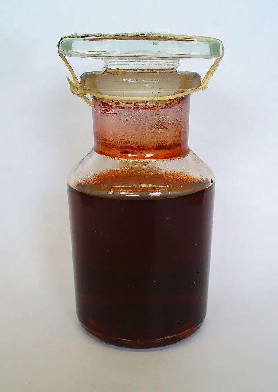 Frasco de vidrio antiguo con extracto rojo carmín